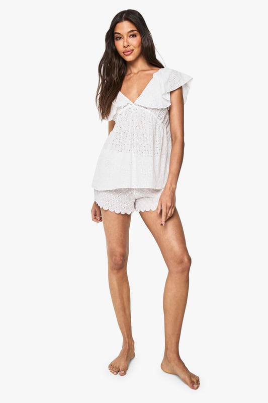 Bridal Broderie Anglaise Frill Cami Top & Shorts Pyjama Set Delicate broderie anglaise fabric with intricate eyelet detailing throughout
Feminine cami top with romantic V-neckline and charming frill overlay
Relaxed fit design for ultimate comfort during your special night
Matching shorts with scalloped hem for a coordinated bridal look
Soft woven fabric that feels gentle against the skin
Make your wedding night as special as your big day with this enchanting broderie anglaise pyjama set from Boohoo. The delicate eyelet detailing and feminine frills create a romantic aesthetic that's perfect for your bridal celebration. The flattering V-neckline and loose-fitting silhouette ensure both style and comfort as you unwind after your wedding festivities. Style with tousled hair and minimal jewellery for an effortlessly beautiful bridal nightwear look. This charming two-piece set strikes the perfect balance between comfort and elegance, making it an ideal addition to your wedding trousseau. The scalloped hem shorts complement the frill-detailed cami top beautifully, creating a cohesive set you'll treasure beyond your wedding night.