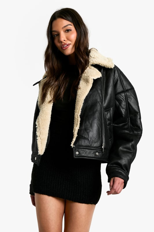 Striking contrast between dark exterior and plush Borg lining
        Oversized fit for a bold, contemporary silhouette
        Notched lapels with Borg trim for added warmth
        Practical side pockets for essentials
        Versatile cropped length suitable for various outfits
    
    Make a statement with this eye-catching Fliegerjacke, a modern twist on the classic aviator style. The contrasting Borg lining not only adds warmth but also creates a visually striking element when the jacket is open. Perfect for those chilly autumn days or cool spring evenings, this jacket effortlessly combines practicality with style. Pair it with a sleek black mini dress and chunky boots for an edgy night out look, or throw it over a casual jumper and jeans combo for weekend brunches. The oversized fit allows for easy layering, making it a versatile piece in your wardrobe. Whether you're heading to a casual family gathering or meeting friends for coffee, this Fliegerjacke will ensure you stay cosy while looking effortlessly cool. Its ability to complement both dressed-up and laid-back outfits makes it a must-have for the fashion-forward Boohoo girl who values both style and versatility.