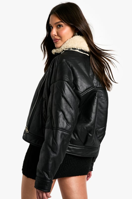 Striking contrast between dark exterior and plush Borg lining
        Oversized fit for a bold, contemporary silhouette
        Notched lapels with Borg trim for added warmth
        Practical side pockets for essentials
        Versatile cropped length suitable for various outfits
    
    Make a statement with this eye-catching Fliegerjacke, a modern twist on the classic aviator style. The contrasting Borg lining not only adds warmth but also creates a visually striking element when the jacket is open. Perfect for those chilly autumn days or cool spring evenings, this jacket effortlessly combines practicality with style. Pair it with a sleek black mini dress and chunky boots for an edgy night out look, or throw it over a casual jumper and jeans combo for weekend brunches. The oversized fit allows for easy layering, making it a versatile piece in your wardrobe. Whether you're heading to a casual family gathering or meeting friends for coffee, this Fliegerjacke will ensure you stay cosy while looking effortlessly cool. Its ability to complement both dressed-up and laid-back outfits makes it a must-have for the fashion-forward Boohoo girl who values both style and versatility.