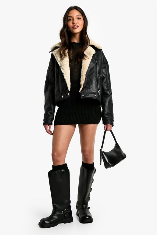 Striking contrast between dark exterior and plush Borg lining
        Oversized fit for a bold, contemporary silhouette
        Notched lapels with Borg trim for added warmth
        Practical side pockets for essentials
        Versatile cropped length suitable for various outfits
    
    Make a statement with this eye-catching Fliegerjacke, a modern twist on the classic aviator style. The contrasting Borg lining not only adds warmth but also creates a visually striking element when the jacket is open. Perfect for those chilly autumn days or cool spring evenings, this jacket effortlessly combines practicality with style. Pair it with a sleek black mini dress and chunky boots for an edgy night out look, or throw it over a casual jumper and jeans combo for weekend brunches. The oversized fit allows for easy layering, making it a versatile piece in your wardrobe. Whether you're heading to a casual family gathering or meeting friends for coffee, this Fliegerjacke will ensure you stay cosy while looking effortlessly cool. Its ability to complement both dressed-up and laid-back outfits makes it a must-have for the fashion-forward Boohoo girl who values both style and versatility.