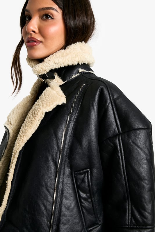 Striking contrast between dark exterior and plush Borg lining
        Oversized fit for a bold, contemporary silhouette
        Notched lapels with Borg trim for added warmth
        Practical side pockets for essentials
        Versatile cropped length suitable for various outfits
    
    Make a statement with this eye-catching Fliegerjacke, a modern twist on the classic aviator style. The contrasting Borg lining not only adds warmth but also creates a visually striking element when the jacket is open. Perfect for those chilly autumn days or cool spring evenings, this jacket effortlessly combines practicality with style. Pair it with a sleek black mini dress and chunky boots for an edgy night out look, or throw it over a casual jumper and jeans combo for weekend brunches. The oversized fit allows for easy layering, making it a versatile piece in your wardrobe. Whether you're heading to a casual family gathering or meeting friends for coffee, this Fliegerjacke will ensure you stay cosy while looking effortlessly cool. Its ability to complement both dressed-up and laid-back outfits makes it a must-have for the fashion-forward Boohoo girl who values both style and versatility.