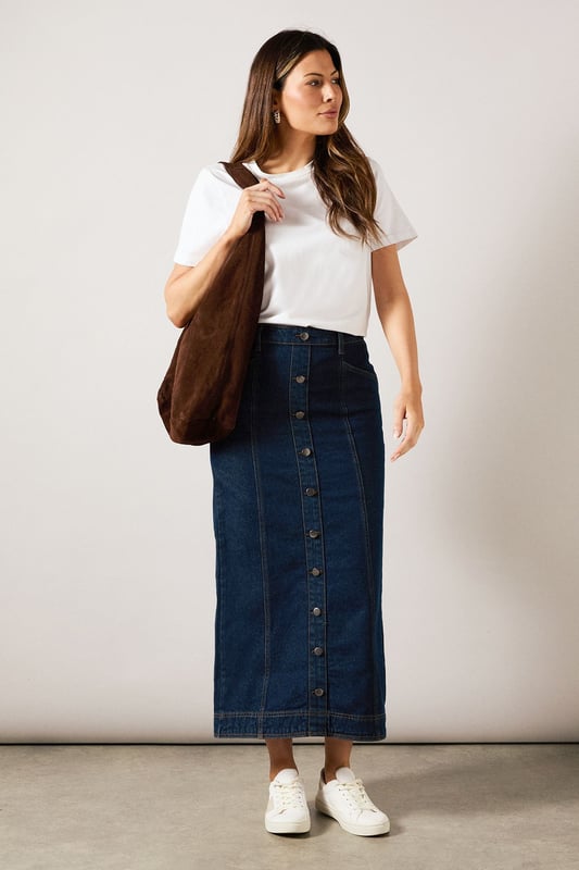 Striking midaxi length denim skirt with distinctive vertical seam detailing
        Front button-through design with metal buttons for a classic denim aesthetic
        Practical side pockets perfect for everyday essentials
        Flattering A-line silhouette that gently flares from the waist
        Subtle back slit detail for ease of movement and added comfort
    
    This sophisticated Seam Detail Midaxi Denim Skirt from Wallis combines timeless style with contemporary design. The vertical seam detailing creates a slimming effect while the classic button-through front adds a touch of casual charm. Style with a simple white t-shirt and leather sandals for relaxed weekend brunches, or pair with a tucked-in blouse and ballet flats for family gatherings. The versatile midaxi length works beautifully for various daytime occasions, from shopping trips to casual lunch dates. For cooler days, layer with a lightweight jumper and trainers for an effortlessly chic look. The cotton fabric provides breathable comfort throughout the day, while the practical pockets add functionality to this wardrobe staple. This skirt transitions seamlessly from season to season, making it a truly versatile addition to your casual collection.