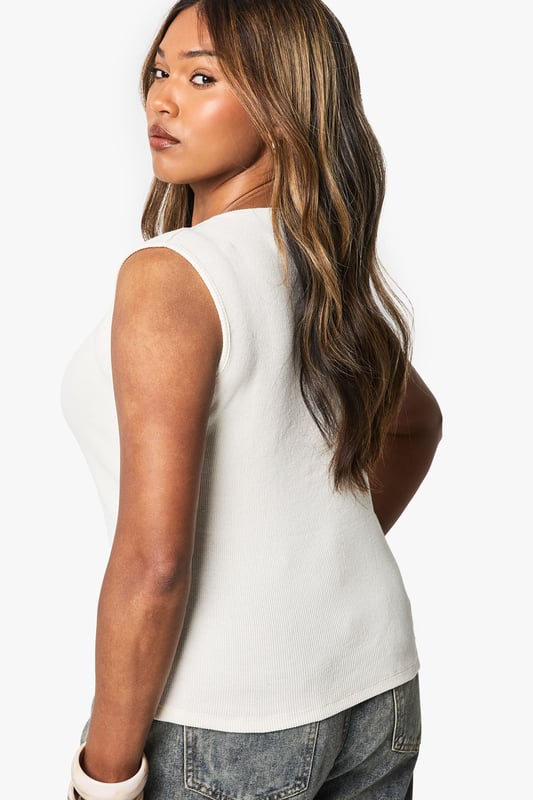 Asymmetrical design with a unique front split
        Sleeveless style for a cool, breezy feel
        Button-down front closure adds a chic touch
        Versatile jersey fabric for comfort and style
        Plus-size fit tailored for curvy figures
    
    Make a statement with this eye-catching asymmetrical top from Boohoo. The sleek, sleeveless design is perfect for those warm summer days, while the button-down front adds a touch of sophistication. The jersey fabric ensures all-day comfort, making it ideal for various casual occasions. Style it with acid-wash jeans and trainers for a trendy daytime look, or dress it up with a midi skirt and strappy sandals for evening drinks with friends. The asymmetrical hem creates a flattering silhouette, perfect for family gatherings or casual outings. Layer it with a lightweight cardigan for cooler evenings, or pair it with statement jewellery to elevate your ensemble. This versatile top is a must-have addition to any fashion-forward wardrobe, offering endless styling possibilities for the confident, curve-embracing Boohoo woman.