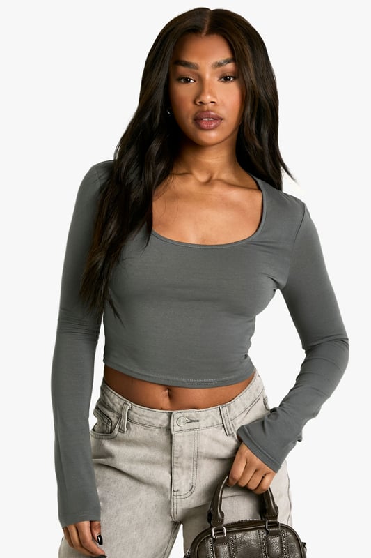Flattering scoop neckline for a feminine touch
        Cropped length to showcase your midriff
        Form-fitting silhouette accentuates curves
        Long sleeves for versatile styling options
        Seamless design for a smooth, streamlined look
    
    This long-sleeved basic scoop neck top is a wardrobe essential that combines comfort with style. The cropped length and figure-hugging fit make it perfect for pairing with high-waisted trousers or skirts, creating a balanced silhouette. Ideal for casual outings, this versatile piece can be dressed up or down effortlessly. Layer it under a blazer for a smart-casual look, or wear it on its own with your favourite jeans for a relaxed day out. The scoop neckline adds a touch of allure, making it suitable for everything from coffee dates to casual Fridays at the office. Its simplicity allows for easy accessorising - throw on a statement necklace or layer delicate chains for added interest. This top is a go-to for creating countless outfits, ensuring you're always ready for impromptu plans or laid-back weekends.