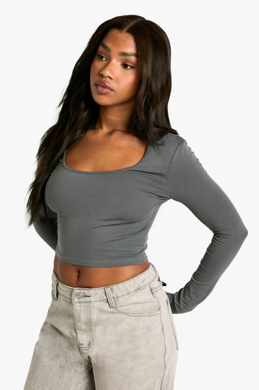 Flattering scoop neckline for a feminine touch
        Cropped length to showcase your midriff
        Form-fitting silhouette accentuates curves
        Long sleeves for versatile styling options
        Seamless design for a smooth, streamlined look
    
    This long-sleeved basic scoop neck top is a wardrobe essential that combines comfort with style. The cropped length and figure-hugging fit make it perfect for pairing with high-waisted trousers or skirts, creating a balanced silhouette. Ideal for casual outings, this versatile piece can be dressed up or down effortlessly. Layer it under a blazer for a smart-casual look, or wear it on its own with your favourite jeans for a relaxed day out. The scoop neckline adds a touch of allure, making it suitable for everything from coffee dates to casual Fridays at the office. Its simplicity allows for easy accessorising - throw on a statement necklace or layer delicate chains for added interest. This top is a go-to for creating countless outfits, ensuring you're always ready for impromptu plans or laid-back weekends.
