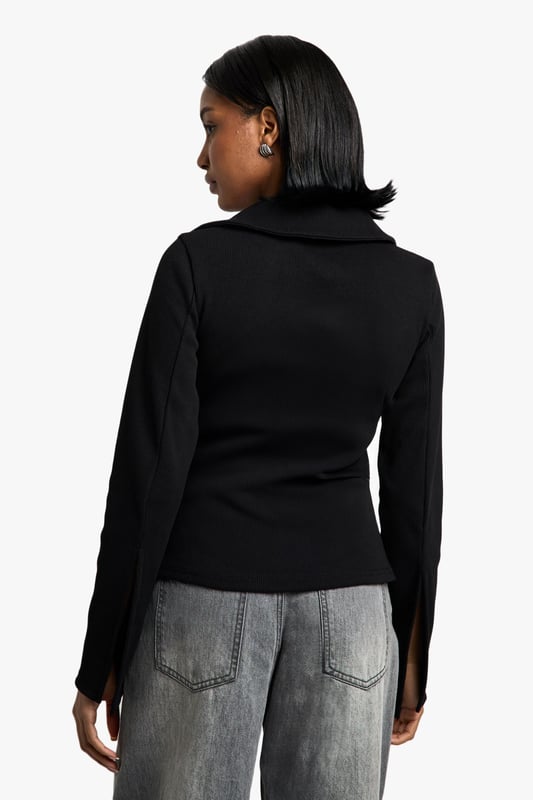 Chic collared long-sleeve top
        Fitted silhouette for a flattering shape
        Versatile open-front design
        Ribbed texture for added interest
        Cropped length to accentuate the waist
    
    This long-sleeved collared top from Boohoo is the perfect blend of sophistication and edge. The fitted silhouette hugs your curves, while the open front design allows for endless styling possibilities. Pair it with high-waisted wide-leg jeans and trainers for a casual day out, or dress it up with a sleek midi skirt and heels for a night on the town. The ribbed texture adds a touch of intrigue, making it stand out from your average top. Its versatility shines through as it can be worn open as a lightweight jacket or closed for a more polished look. The cropped length is ideal for highlighting your waistline and works brilliantly with high-rise bottoms. Whether you're heading to a family gathering or meeting friends for brunch, this top will keep you looking effortlessly stylish.