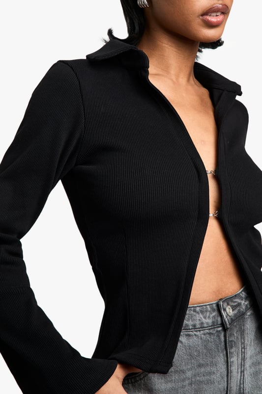Chic collared long-sleeve top
        Fitted silhouette for a flattering shape
        Versatile open-front design
        Ribbed texture for added interest
        Cropped length to accentuate the waist
    
    This long-sleeved collared top from Boohoo is the perfect blend of sophistication and edge. The fitted silhouette hugs your curves, while the open front design allows for endless styling possibilities. Pair it with high-waisted wide-leg jeans and trainers for a casual day out, or dress it up with a sleek midi skirt and heels for a night on the town. The ribbed texture adds a touch of intrigue, making it stand out from your average top. Its versatility shines through as it can be worn open as a lightweight jacket or closed for a more polished look. The cropped length is ideal for highlighting your waistline and works brilliantly with high-rise bottoms. Whether you're heading to a family gathering or meeting friends for brunch, this top will keep you looking effortlessly stylish.