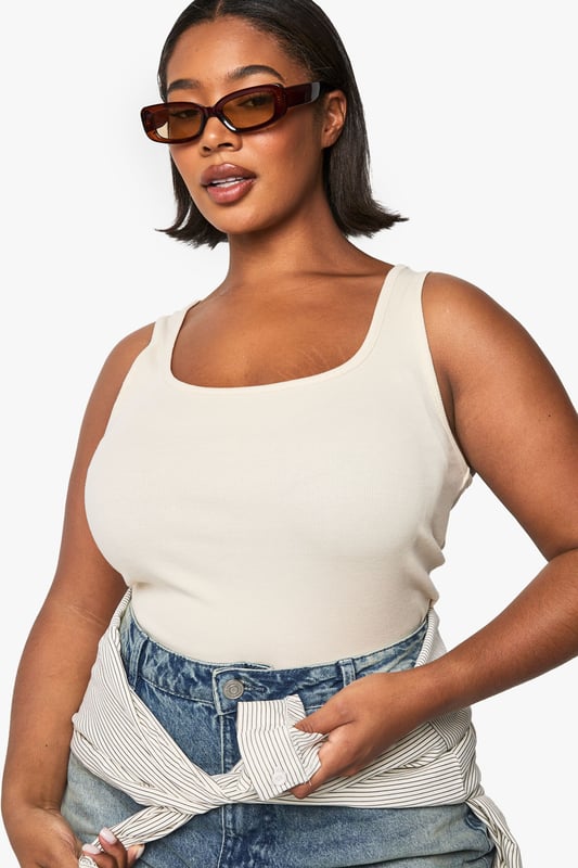 PLUS RIB SCOOP NECK RACER BACK VEST TOP Ribbed texture for added visual interest and comfortable stretch
Flattering scoop neckline frames the dcolletage beautifully
Sleeveless racer design offers unrestricted movement
Figure-hugging fit showcases your curves with confidence
Versatile length perfect for tucking or wearing untucked
This ribbed racer top from Boohoo is the essential foundation piece your wardrobe craves. The sleek, body-contouring silhouette pairs effortlessly with virtually anything - style with wide-leg jeans and trainers for casual coffee dates, or tuck into a high-waisted skirt with heels for evening drinks. The scoop neckline adds a feminine touch while the ribbed fabric offers just the right amount of stretch for all-day comfort. As seen on our model, try layering with an oversized shirt tied at the waist for an on-trend athleisure look that transitions seamlessly from running errands to casual meetups. This plus-size staple works brilliantly year-round - wear solo during warmer months or as a layering piece when temperatures drop.
