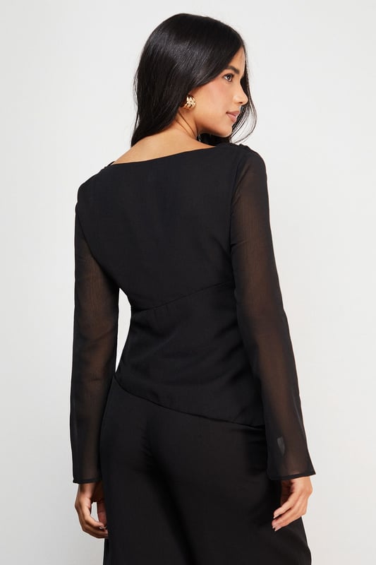 Elegant chiffon top featuring a sophisticated asymmetric design
        Flattering gathered waist detail creates a feminine silhouette
        Sheer long sleeves add a touch of subtle allure
        Versatile boat neckline frames the dcolletage beautifully
        Fully lined body ensures comfort and proper coverage
    
    This Warehouse chiffon top combines contemporary design with effortless wearability. The asymmetric gathering at the waist creates a flattering drape that complements your natural shape, whilst the sheer sleeves add a delicate contrast to the lined body. Style with wide-leg trousers as shown for a sophisticated daytime look, or dress up with tailored cigarette trousers and statement earrings for evening drinks. The versatile design transitions seamlessly from office to weekend brunch, making it a wardrobe essential for the modern British woman. For casual family gatherings, pair with your favourite denim and ballet flats, or dress it up with a sleek blazer and heeled boots for dinner dates. Machine washable for practical everyday wear.