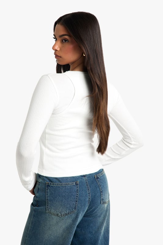 2 Layer Rib Long Sleeve Top Double-layered ribbed design for added texture and warmth
Long sleeves for versatile seasonal wear
Fitted silhouette accentuates curves
Crew neckline for a classic finish
Cropped length perfect for high-waisted bottoms
This double-layered ribbed top is a wardrobe essential that combines comfort with style. The long sleeves and fitted silhouette make it ideal for layering or wearing on its own, adapting effortlessly to your daily needs. Pair it with wide-leg jeans and trainers for a casual day out, or dress it up with a midi skirt and ankle boots for a chic evening look. The versatile design allows for endless styling possibilities, making it perfect for everything from coffee dates to casual Fridays at the office. The cropped length works brilliantly with high-waisted trousers or skirts, creating a balanced and flattering silhouette. Add a statement necklace or a colourful scarf to personalise your look and make this simple yet stylish top uniquely yours.