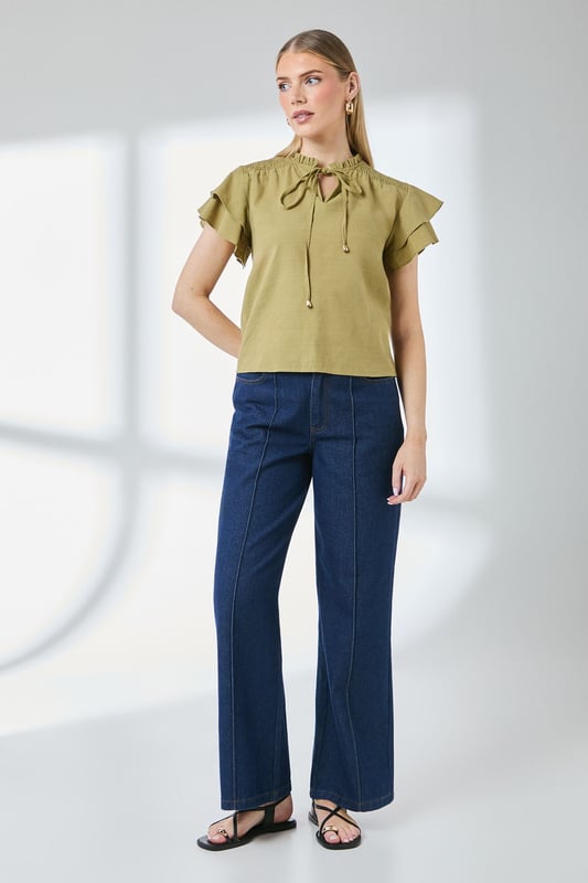 Charming bubble hem design creates a flattering silhouette
        Feminine flute sleeves with delicate ruffle detail
        Elegant V-neckline with tie detail for adjustable styling
        Gathered neckline adds texture and visual interest
        Regular fit in soft cotton-blend fabric for all-day comfort
    
    This Principles top combines playful elements with everyday wearability. The distinctive bubble hem creates a relaxed shape that skims the body beautifully, whilst the flute sleeves add a touch of feminine flair. Style with your favourite denim jeans and trainers for weekend brunches, or dress up with tailored trousers and ballet flats for casual office days. The versatile design works brilliantly for family gatherings and informal social occasions - simply add statement earrings and a crossbody bag to complete the look. The cotton-blend fabric ensures breathability and comfort throughout the day, making this top a practical yet stylish addition to your daywear collection. Perfect for the transitional seasons when layered under a lightweight cardigan or denim jacket.