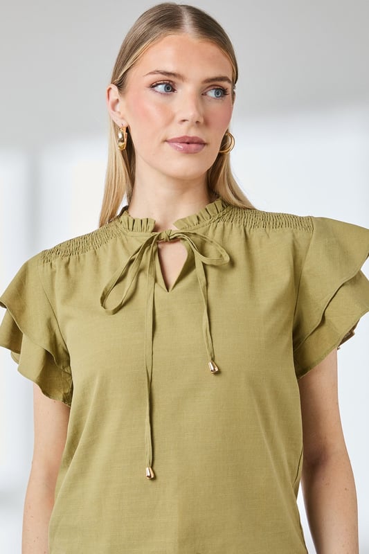 Charming bubble hem design creates a flattering silhouette
        Feminine flute sleeves with delicate ruffle detail
        Elegant V-neckline with tie detail for adjustable styling
        Gathered neckline adds texture and visual interest
        Regular fit in soft cotton-blend fabric for all-day comfort
    
    This Principles top combines playful elements with everyday wearability. The distinctive bubble hem creates a relaxed shape that skims the body beautifully, whilst the flute sleeves add a touch of feminine flair. Style with your favourite denim jeans and trainers for weekend brunches, or dress up with tailored trousers and ballet flats for casual office days. The versatile design works brilliantly for family gatherings and informal social occasions - simply add statement earrings and a crossbody bag to complete the look. The cotton-blend fabric ensures breathability and comfort throughout the day, making this top a practical yet stylish addition to your daywear collection. Perfect for the transitional seasons when layered under a lightweight cardigan or denim jacket.