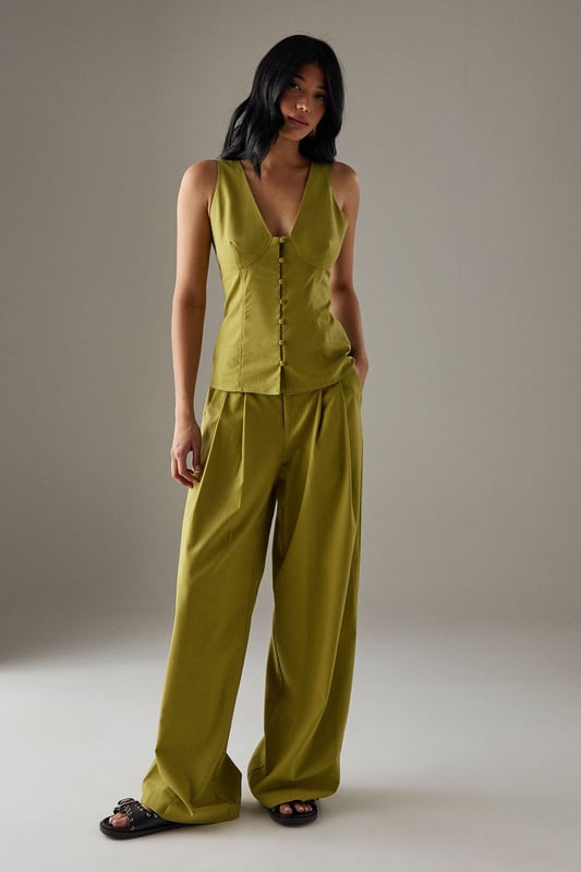 Sleeveless button-through design with striking plunging V-neckline
        Structured bodice with flattering seam detailing for a defined silhouette
        Elegant square-cut back adding a contemporary twist
        Linen blend fabric offering breathable comfort with natural texture
        Versatile length perfect for tucking or wearing loose
    
    This sophisticated sleeveless top from Warehouse radiates confidence with its bold V-neckline and button-through front. The structured bodice creates a feminine silhouette that works beautifully for daytime occasions. Style with the matching wide-leg trousers as shown for an effortlessly coordinated look, or pair with your favourite denim and trainers for casual weekend brunches. The square-cut back adds interest when layered under a lightweight cardigan or denim jacket for cooler days. Perfect for family gatherings or alfresco dining, this versatile piece transitions seamlessly from day to evening - simply swap your flat sandals for block heels and add statement jewellery. The textured linen blend fabric offers a natural drape that maintains its shape throughout the day whilst providing breathable comfort.
