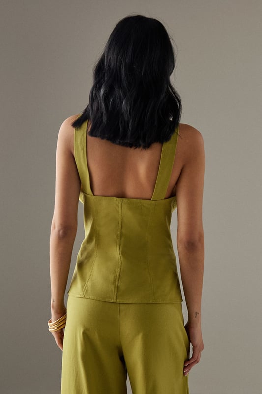Sleeveless button-through design with striking plunging V-neckline
        Structured bodice with flattering seam detailing for a defined silhouette
        Elegant square-cut back adding a contemporary twist
        Linen blend fabric offering breathable comfort with natural texture
        Versatile length perfect for tucking or wearing loose
    
    This sophisticated sleeveless top from Warehouse radiates confidence with its bold V-neckline and button-through front. The structured bodice creates a feminine silhouette that works beautifully for daytime occasions. Style with the matching wide-leg trousers as shown for an effortlessly coordinated look, or pair with your favourite denim and trainers for casual weekend brunches. The square-cut back adds interest when layered under a lightweight cardigan or denim jacket for cooler days. Perfect for family gatherings or alfresco dining, this versatile piece transitions seamlessly from day to evening - simply swap your flat sandals for block heels and add statement jewellery. The textured linen blend fabric offers a natural drape that maintains its shape throughout the day whilst providing breathable comfort.