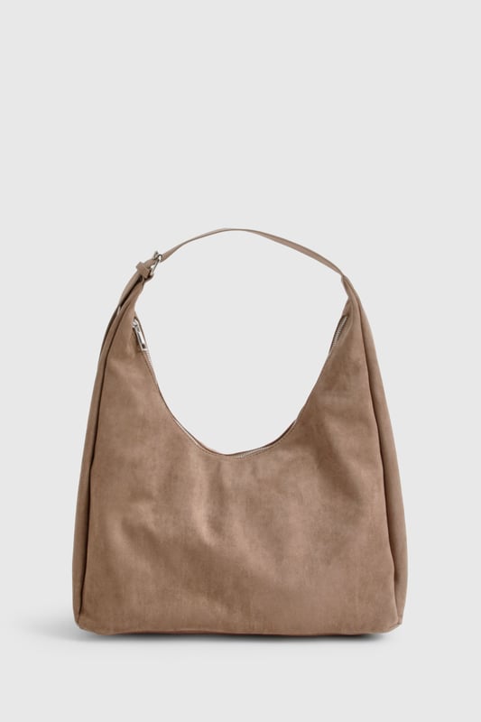 Soft faux suede shoulder bag with a spacious hobo silhouette
        Single adjustable shoulder strap for comfortable carrying
        Roomy interior perfect for everyday essentials
        Minimalist design with clean lines and no external embellishments
        Versatile shape that complements both casual and smart-casual outfits
    
    This faux suede shoulder bag combines practicality with effortless style. The slouchy hobo design offers ample space for your daily necessities whilst maintaining a relaxed aesthetic that works brilliantly with your everyday wardrobe. As shown, pair with denim for a classic daytime look, or match with floaty dresses and ankle boots for weekend brunches. The neutral tone makes it an ideal companion for autumn/winter layering or spring transitional outfits. Perfect for shopping trips, coffee dates or casual workdays, this Boohoo bag strikes the balance between functionality and fashion. The minimalist design ensures it won't compete with your outfit but rather complement it, making this an essential addition to your accessories collection that will serve you season after season.