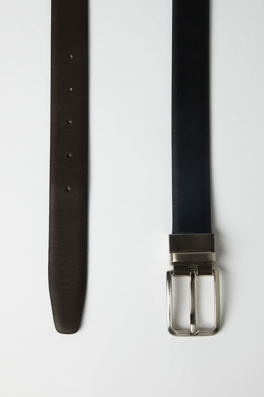 Reversible design offers two distinct looks in one versatile belt
        Sleek metal buckle with rectangular frame for a contemporary finish
        Multiple belt holes for adjustable comfort and perfect fit
        Crafted from genuine leather for durability and timeless appeal
        Clean-edge construction provides a refined, sophisticated silhouette
    
    This reversible leather belt delivers exceptional versatility for the modern gentleman. Effortlessly transition between smart and casual settings by simply flipping the belt to reveal its alternate side. The understated rectangular buckle complements both formal trousers and smart denim alike, making it an essential wardrobe staple. Style with tailored grey trousers and a crisp white shirt for important meetings, or pair with chinos and a button-down for weekend gatherings at the local. The genuine leather construction ensures this belt will age beautifully with wear, developing a unique patina over time. Perfect for the man who appreciates classic styling with practical functionality - this belt offers enduring style that works seamlessly from office to evening drinks without missing a beat.