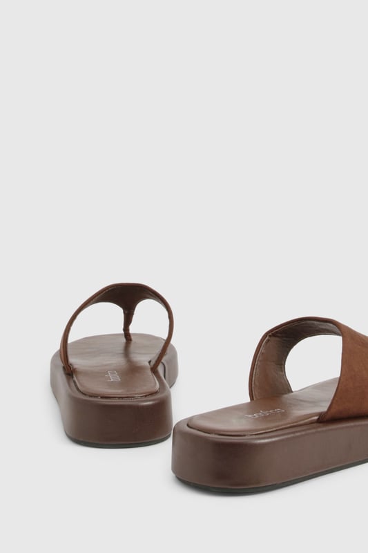 Wide fit design for enhanced comfort and all-day wearability
        Chunky platform sole with flat heel (under 2cm) for added height without sacrificing stability
        Faux suede toe post strap with soft finish for reduced friction
        Cushioned footbed providing support for extended wear
        Durable thermoplastic sole offering excellent grip on various surfaces
    
    These wide fit chunky flip-flops combine contemporary style with practical comfort. The faux suede upper creates a textural contrast against the substantial platform sole, making them a versatile addition to your summer wardrobe. Perfect for casual outings, pair them with flowing maxi dresses and oversized sunglasses for beach days, or style with cropped linen trousers and a simple tee for weekend brunches. Their comfortable design makes them ideal for city explorations or garden gatherings when the weather warms. The neutral tone works effortlessly with both vibrant prints and muted ensembles, while the wide fit ensures comfort for all foot shapes. These Boohoo flip-flops offer the perfect blend of on-trend styling and practical design for the fashion-conscious woman seeking both comfort and style this season.