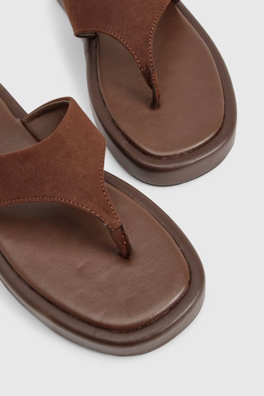Wide fit design for enhanced comfort and all-day wearability
        Chunky platform sole with flat heel (under 2cm) for added height without sacrificing stability
        Faux suede toe post strap with soft finish for reduced friction
        Cushioned footbed providing support for extended wear
        Durable thermoplastic sole offering excellent grip on various surfaces
    
    These wide fit chunky flip-flops combine contemporary style with practical comfort. The faux suede upper creates a textural contrast against the substantial platform sole, making them a versatile addition to your summer wardrobe. Perfect for casual outings, pair them with flowing maxi dresses and oversized sunglasses for beach days, or style with cropped linen trousers and a simple tee for weekend brunches. Their comfortable design makes them ideal for city explorations or garden gatherings when the weather warms. The neutral tone works effortlessly with both vibrant prints and muted ensembles, while the wide fit ensures comfort for all foot shapes. These Boohoo flip-flops offer the perfect blend of on-trend styling and practical design for the fashion-conscious woman seeking both comfort and style this season.