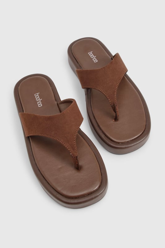 Wide fit design for enhanced comfort and all-day wearability
        Chunky platform sole with flat heel (under 2cm) for added height without sacrificing stability
        Faux suede toe post strap with soft finish for reduced friction
        Cushioned footbed providing support for extended wear
        Durable thermoplastic sole offering excellent grip on various surfaces
    
    These wide fit chunky flip-flops combine contemporary style with practical comfort. The faux suede upper creates a textural contrast against the substantial platform sole, making them a versatile addition to your summer wardrobe. Perfect for casual outings, pair them with flowing maxi dresses and oversized sunglasses for beach days, or style with cropped linen trousers and a simple tee for weekend brunches. Their comfortable design makes them ideal for city explorations or garden gatherings when the weather warms. The neutral tone works effortlessly with both vibrant prints and muted ensembles, while the wide fit ensures comfort for all foot shapes. These Boohoo flip-flops offer the perfect blend of on-trend styling and practical design for the fashion-conscious woman seeking both comfort and style this season.