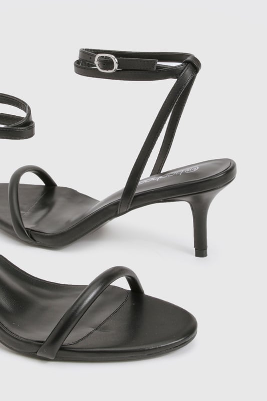 Elegant strappy design with delicate ankle wrap detail
        Low heel height between 2.5-4.5cm for comfortable all-night wear
        Minimalist open-toe silhouette for a contemporary look
        Secure ankle buckle fastening for adjustable fit
        Versatile styling potential for both casual and dressed-up occasions
    
    These essential Basic Heels from Boohoo deliver the perfect balance of style and practicality for your night-out wardrobe. The sleek, minimalist design features thin straps that gracefully frame the foot, while the ankle wrap detail adds a touch of sophistication. The low heel provides just enough height to enhance your silhouette without sacrificing comfort during long evenings out. Style these versatile heels with a figure-hugging midi dress and statement earrings for cocktails with the girls, or pair with your favourite jeans and a silky camisole for a more relaxed evening look. The understated design makes these heels an ideal foundation piece for countless outfits, ensuring they'll become a go-to choice whenever you're planning a night on the town. Their timeless appeal means they'll remain a staple in your collection season after season.