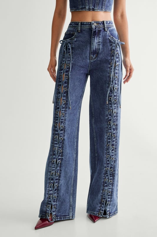 Striking lace-up detail along the sides
        High-waisted design for a flattering silhouette
        Wide-leg cut for a trendy, relaxed look
        Cropped top with square neckline and thick straps
        Back lace-up closure on the top for adjustable fit
    
    Make a bold statement with these eye-catching jeans from NastyGal. The standout lace-up detail running along the sides adds a daring edge to your casual ensemble. Pair with the matching cropped top for a coordinated look that's sure to turn heads. The high-waisted, wide-leg cut is perfect for creating a long, lean silhouette. Style with chunky trainers for a laid-back vibe, or dress up with heeled boots for evening drinks. These versatile jeans are ideal for family gatherings, brunches with friends, or casual Friday at the office. The denim fabric offers comfort and durability, making these jeans a wardrobe staple you'll reach for time and time again.