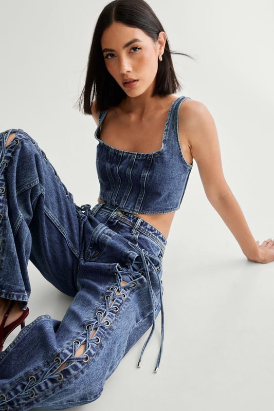 Striking lace-up detail along the sides
        High-waisted design for a flattering silhouette
        Wide-leg cut for a trendy, relaxed look
        Cropped top with square neckline and thick straps
        Back lace-up closure on the top for adjustable fit
    
    Make a bold statement with these eye-catching jeans from NastyGal. The standout lace-up detail running along the sides adds a daring edge to your casual ensemble. Pair with the matching cropped top for a coordinated look that's sure to turn heads. The high-waisted, wide-leg cut is perfect for creating a long, lean silhouette. Style with chunky trainers for a laid-back vibe, or dress up with heeled boots for evening drinks. These versatile jeans are ideal for family gatherings, brunches with friends, or casual Friday at the office. The denim fabric offers comfort and durability, making these jeans a wardrobe staple you'll reach for time and time again.