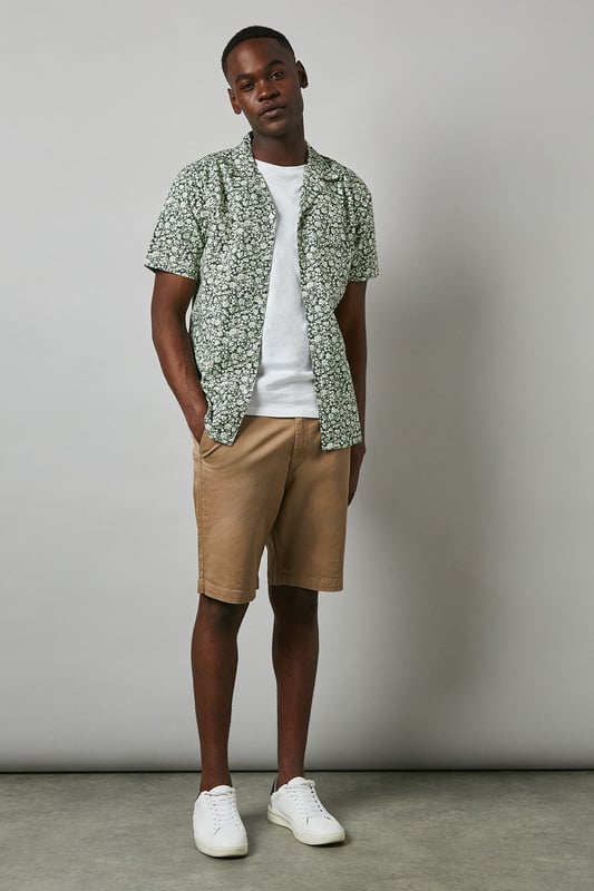 Distinctive revere collar design for a relaxed, open neckline aesthetic
        All-over floral print pattern adding visual interest and seasonal charm
        Short sleeve construction perfect for warmer weather comfort
        Cotton fabric offering breathable wear throughout the day
        Versatile regular fit that suits various body types
    
    This Maine floral print revere shirt brings a refreshing twist to casual dressing. The eye-catching pattern creates a focal point for any outfit, while the comfortable cotton construction ensures all-day wearability. Style as seen on our model with neutral chino shorts and crisp white trainers for an effortlessly cool summer look. For evening socials, pair with slim-fit trousers and loafers to transition seamlessly from day to night. The revere collar adds a touch of laid-back sophistication that works brilliantly for garden parties, weekend brunches or holiday getaways. This shirt can be worn buttoned up or open over a plain t-shirt for two distinct styling options, making it a versatile addition to your warm-weather wardrobe. Perfect for those seeking to inject personality into their casual collection.