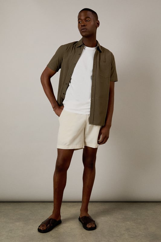 Textured seersucker fabric adds subtle dimension and visual interest
        Classic short sleeve design with traditional collar for timeless appeal
        Single chest pocket detail for practical functionality
        Button-through front with clean finish for easy styling
        Relaxed cut allows for comfortable movement throughout the day
    
    This seersucker short sleeve shirt from Burton delivers effortless style for the modern man who values both comfort and classic design. The distinctive textured fabric is naturally breathable, making it ideal for warmer days when you need to stay cool yet look put-together. Pair with chino shorts as shown for casual weekend outings or garden gatherings. For a smart-casual look, team with tailored trousers and loafers when heading to the pub with mates or a relaxed family lunch. The versatile nature of this shirt means it works equally well layered over a plain t-shirt or worn alone. Machine washable at 30 degrees, this low-maintenance essential will quickly become a go-to in your warm-weather rotation, offering that perfect balance of relaxed sophistication that Burton is known for.