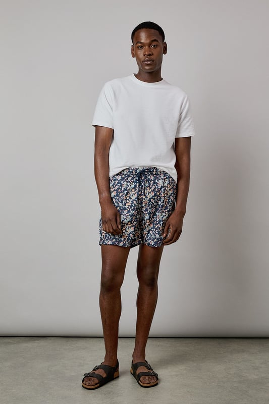 Eye-catching sunset camo print design for standout poolside style
        Quick-drying fabric for comfort both in and out of the water
        Adjustable drawstring waist for a customised fit
        Practical side pockets for essentials
        Mid-thigh length offering comfortable coverage and freedom of movement
    
    These Burton swim shorts showcase a distinctive sunset camo print that brings character to your holiday wardrobe. Perfect for beach days, pool parties or casual summer outings, they offer both style and practicality. The mid-thigh length presents a modern silhouette that suits most body types, while the adjustable waistband ensures comfort throughout the day. Style them as seen with a crisp white t-shirt and sandals for an effortless daytime look, or pair with a linen shirt when heading from beach to bar. These versatile shorts transition seamlessly from swimming to socialising, making them an essential for summer getaways, garden barbecues or simply relaxing at your local lido. Ideal for the man who appreciates classic styling with a contemporary twist, these swim shorts will become a seasonal favourite in your warm-weather collection.