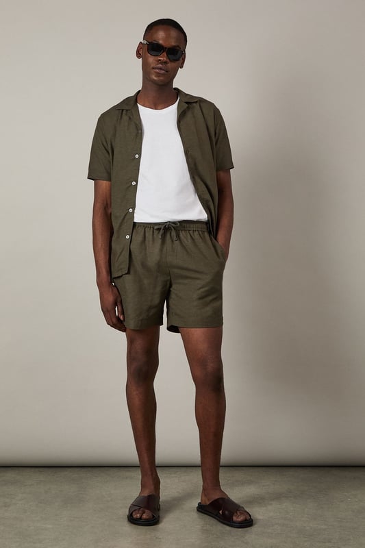 Khaki Linen Blend Shorts Linen blend fabric offers breathable comfort for warmer days
Relaxed fit with mid-thigh length for easy movement
Adjustable drawstring waist for a customised fit
Side pockets for practicality and casual styling
Back pocket detail adds functional finishing touch
These versatile linen blend shorts are the cornerstone of any summer wardrobe. Perfect for casual weekend outings, they pair effortlessly with a crisp white tee and matching shirt as shown for a coordinated look that works brilliantly for beer garden meetups or family barbecues. The textured fabric adds subtle interest while maintaining a classic appeal that Burton is known for. Style with leather sandals for relaxed holiday vibes, or switch to canvas trainers for a sportier aesthetic when heading to the pub with mates. For cooler evenings, simply add a light knit or casual bomber jacket. These shorts strike the ideal balance between comfort and style - making them an essential for the man who appreciates timeless casual wear with practical features for everyday life.