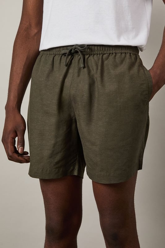 Khaki Linen Blend Shorts Linen blend fabric offers breathable comfort for warmer days
Relaxed fit with mid-thigh length for easy movement
Adjustable drawstring waist for a customised fit
Side pockets for practicality and casual styling
Back pocket detail adds functional finishing touch
These versatile linen blend shorts are the cornerstone of any summer wardrobe. Perfect for casual weekend outings, they pair effortlessly with a crisp white tee and matching shirt as shown for a coordinated look that works brilliantly for beer garden meetups or family barbecues. The textured fabric adds subtle interest while maintaining a classic appeal that Burton is known for. Style with leather sandals for relaxed holiday vibes, or switch to canvas trainers for a sportier aesthetic when heading to the pub with mates. For cooler evenings, simply add a light knit or casual bomber jacket. These shorts strike the ideal balance between comfort and style - making them an essential for the man who appreciates timeless casual wear with practical features for everyday life.