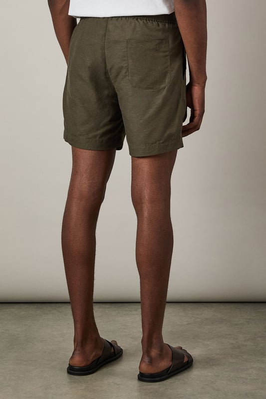 Khaki Linen Blend Shorts Linen blend fabric offers breathable comfort for warmer days
Relaxed fit with mid-thigh length for easy movement
Adjustable drawstring waist for a customised fit
Side pockets for practicality and casual styling
Back pocket detail adds functional finishing touch
These versatile linen blend shorts are the cornerstone of any summer wardrobe. Perfect for casual weekend outings, they pair effortlessly with a crisp white tee and matching shirt as shown for a coordinated look that works brilliantly for beer garden meetups or family barbecues. The textured fabric adds subtle interest while maintaining a classic appeal that Burton is known for. Style with leather sandals for relaxed holiday vibes, or switch to canvas trainers for a sportier aesthetic when heading to the pub with mates. For cooler evenings, simply add a light knit or casual bomber jacket. These shorts strike the ideal balance between comfort and style - making them an essential for the man who appreciates timeless casual wear with practical features for everyday life.