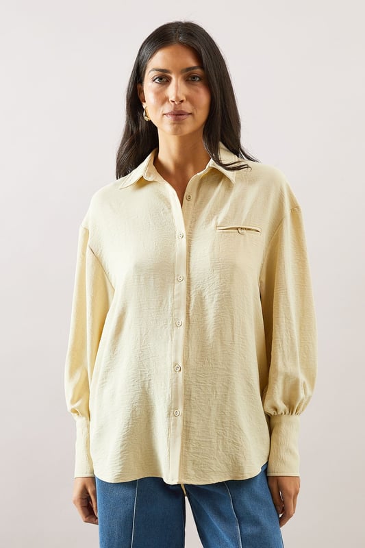 Pocket Detail Relaxed Collared Shirt Relaxed fit collared shirt with elegant chest pocket detail
Voluminous balloon sleeves with fitted cuffs for a feminine silhouette
Soft woven fabric with slight stretch for all-day comfort
Classic button-through front with sophisticated collar design
Curved hem perfect for both tucked or untucked styling options
This versatile Wallis shirt combines sophistication with everyday comfort. The relaxed silhouette drapes beautifully over the body while the distinctive pocket detail adds a touch of refinement. Style it as shown with wide-leg denim trousers and trainers for a polished daytime look, or tuck the front into tailored trousers for family gatherings. The balloon sleeves create a contemporary shape that transitions effortlessly from office to weekend brunch. For cooler days, layer under a lightweight cardigan or pair with your favourite jeans and ankle boots. The collared neckline frames the face beautifully, making this shirt an essential addition to your daywear collection - perfect for those occasions when you want to feel put-together yet comfortable.
