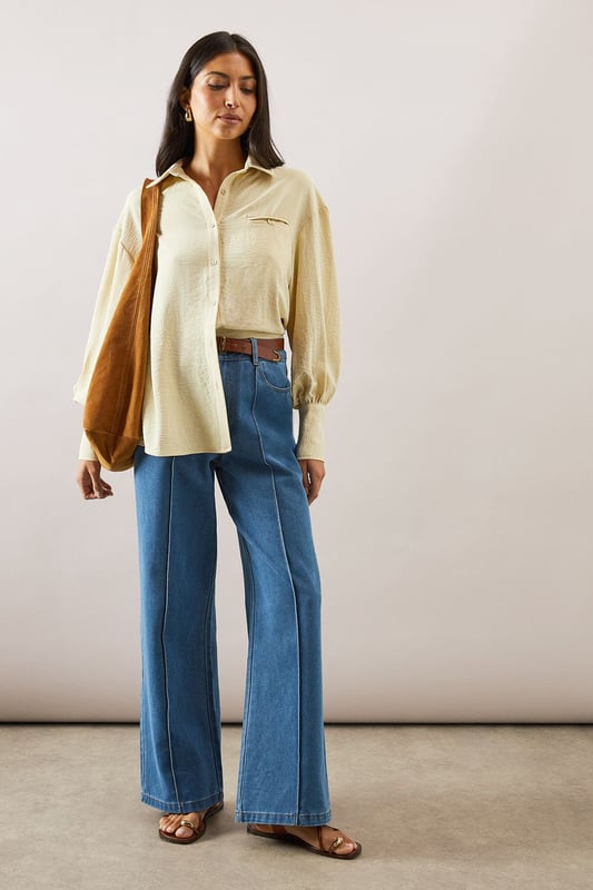 Pocket Detail Relaxed Collared Shirt Relaxed fit collared shirt with elegant chest pocket detail
Voluminous balloon sleeves with fitted cuffs for a feminine silhouette
Soft woven fabric with slight stretch for all-day comfort
Classic button-through front with sophisticated collar design
Curved hem perfect for both tucked or untucked styling options
This versatile Wallis shirt combines sophistication with everyday comfort. The relaxed silhouette drapes beautifully over the body while the distinctive pocket detail adds a touch of refinement. Style it as shown with wide-leg denim trousers and trainers for a polished daytime look, or tuck the front into tailored trousers for family gatherings. The balloon sleeves create a contemporary shape that transitions effortlessly from office to weekend brunch. For cooler days, layer under a lightweight cardigan or pair with your favourite jeans and ankle boots. The collared neckline frames the face beautifully, making this shirt an essential addition to your daywear collection - perfect for those occasions when you want to feel put-together yet comfortable.