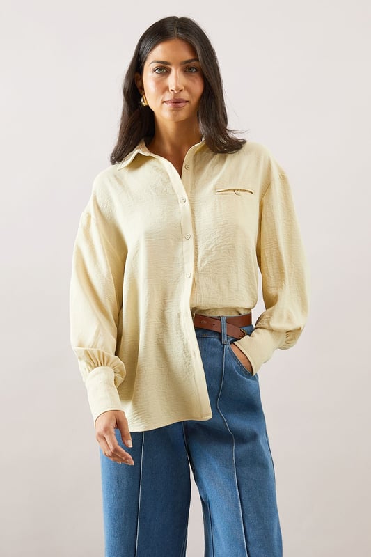 Pocket Detail Relaxed Collared Shirt Relaxed fit collared shirt with elegant chest pocket detail
Voluminous balloon sleeves with fitted cuffs for a feminine silhouette
Soft woven fabric with slight stretch for all-day comfort
Classic button-through front with sophisticated collar design
Curved hem perfect for both tucked or untucked styling options
This versatile Wallis shirt combines sophistication with everyday comfort. The relaxed silhouette drapes beautifully over the body while the distinctive pocket detail adds a touch of refinement. Style it as shown with wide-leg denim trousers and trainers for a polished daytime look, or tuck the front into tailored trousers for family gatherings. The balloon sleeves create a contemporary shape that transitions effortlessly from office to weekend brunch. For cooler days, layer under a lightweight cardigan or pair with your favourite jeans and ankle boots. The collared neckline frames the face beautifully, making this shirt an essential addition to your daywear collection - perfect for those occasions when you want to feel put-together yet comfortable.