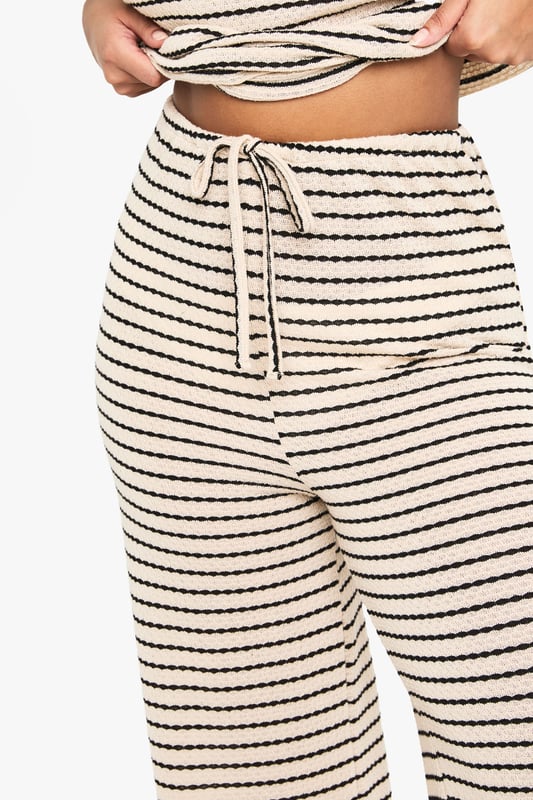 Striking striped pattern for a bold, eye-catching look
        Wide-leg silhouette offers comfort and style
        High-waisted design with drawstring for adjustable fit
        Soft jersey fabric ensures all-day comfort
        Versatile piece suitable for various casual occasions
    
    Make a statement with these trendy wide-leg trousers, perfect for the fashion-forward woman who values both style and comfort. The eye-catching striped pattern adds a touch of flair to your ensemble, while the relaxed wide-leg cut ensures ease of movement. Pair these trousers with a cropped top and oversized sunglasses for a chic daytime look, or dress them up with a fitted blouse and statement jewellery for a casual evening out. The high-waisted design with an adjustable drawstring allows for a customised fit, making these trousers suitable for a range of body types. Ideal for family gatherings, brunches with friends, or a day of shopping, these versatile trousers will quickly become a staple in your wardrobe. The soft jersey fabric promises comfort throughout the day, whether you're running errands or lounging at home. Complete the look with flat sandals or trainers for an effortlessly cool vibe that embodies the Boohoo spirit.