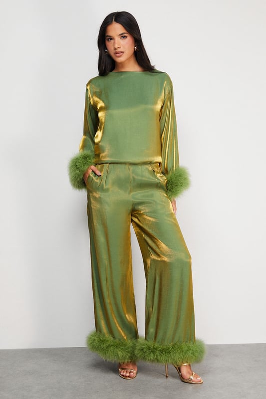 Luxurious feather trim adorning cuffs and hem
        Wide-leg silhouette for a dramatic, flowing effect
        High-waisted design for a flattering fit
        Iridescent fabric adding a subtle shimmer
        Ankle-length cut perfect for showcasing statement footwear
    
    Make a grand entrance at your next formal event with these show-stopping wide-leg trousers from Warehouse. The iridescent fabric catches the light beautifully, whilst the opulent feather trim at the cuffs and hem adds a touch of old Hollywood glamour. Style these trousers with a sleek, fitted top to balance the voluminous silhouette. For an ultra-chic ensemble, pair with metallic platform sandals and a clutch bag. These trousers are versatile enough for a range of occasions, from black-tie galas to winter weddings. The high-waisted cut elongates the legs, creating a statuesque silhouette that's sure to turn heads. Embrace your inner fashionista and let these trousers be the star of your outfit.