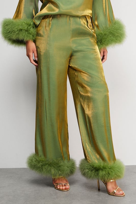 Luxurious feather trim adorning cuffs and hem
        Wide-leg silhouette for a dramatic, flowing effect
        High-waisted design for a flattering fit
        Iridescent fabric adding a subtle shimmer
        Ankle-length cut perfect for showcasing statement footwear
    
    Make a grand entrance at your next formal event with these show-stopping wide-leg trousers from Warehouse. The iridescent fabric catches the light beautifully, whilst the opulent feather trim at the cuffs and hem adds a touch of old Hollywood glamour. Style these trousers with a sleek, fitted top to balance the voluminous silhouette. For an ultra-chic ensemble, pair with metallic platform sandals and a clutch bag. These trousers are versatile enough for a range of occasions, from black-tie galas to winter weddings. The high-waisted cut elongates the legs, creating a statuesque silhouette that's sure to turn heads. Embrace your inner fashionista and let these trousers be the star of your outfit.