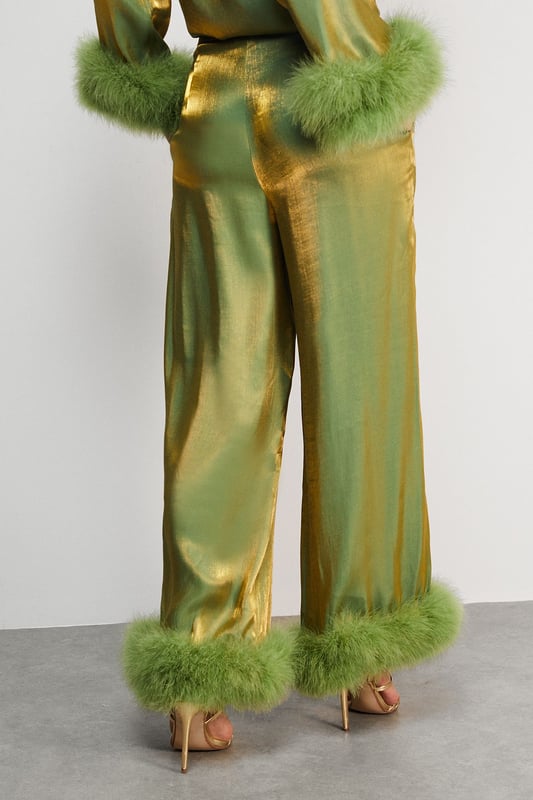Luxurious feather trim adorning cuffs and hem
        Wide-leg silhouette for a dramatic, flowing effect
        High-waisted design for a flattering fit
        Iridescent fabric adding a subtle shimmer
        Ankle-length cut perfect for showcasing statement footwear
    
    Make a grand entrance at your next formal event with these show-stopping wide-leg trousers from Warehouse. The iridescent fabric catches the light beautifully, whilst the opulent feather trim at the cuffs and hem adds a touch of old Hollywood glamour. Style these trousers with a sleek, fitted top to balance the voluminous silhouette. For an ultra-chic ensemble, pair with metallic platform sandals and a clutch bag. These trousers are versatile enough for a range of occasions, from black-tie galas to winter weddings. The high-waisted cut elongates the legs, creating a statuesque silhouette that's sure to turn heads. Embrace your inner fashionista and let these trousers be the star of your outfit.