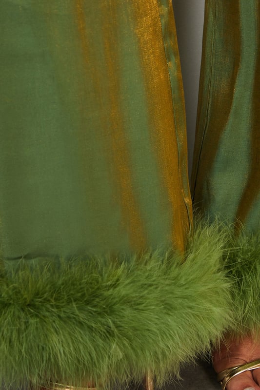 Luxurious feather trim adorning cuffs and hem
        Wide-leg silhouette for a dramatic, flowing effect
        High-waisted design for a flattering fit
        Iridescent fabric adding a subtle shimmer
        Ankle-length cut perfect for showcasing statement footwear
    
    Make a grand entrance at your next formal event with these show-stopping wide-leg trousers from Warehouse. The iridescent fabric catches the light beautifully, whilst the opulent feather trim at the cuffs and hem adds a touch of old Hollywood glamour. Style these trousers with a sleek, fitted top to balance the voluminous silhouette. For an ultra-chic ensemble, pair with metallic platform sandals and a clutch bag. These trousers are versatile enough for a range of occasions, from black-tie galas to winter weddings. The high-waisted cut elongates the legs, creating a statuesque silhouette that's sure to turn heads. Embrace your inner fashionista and let these trousers be the star of your outfit.
