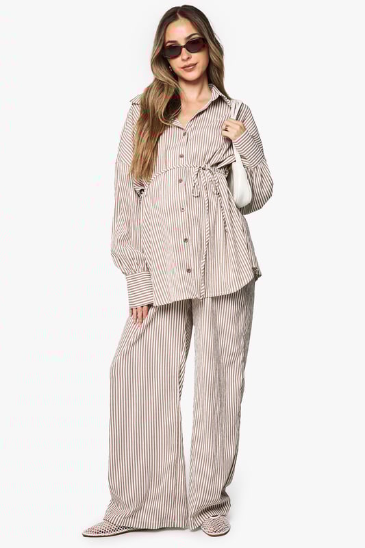 Wide leg maternity trousers with flattering silhouette for growing bumps
        Coordinating belt detail to adjust fit throughout pregnancy
        Vertical stripe pattern creates an elongating effect
        Comfortable high-rise waistband sits above the bump
        Designed to be paired with matching striped shirt for a coordinated look
    
    These boohoo maternity trousers combine comfort and style with their relaxed wide-leg design. The adjustable belt allows you to customise the fit as your body changes, while the vertical stripes create a lengthening effect for a flattering silhouette. Style with the matching button-up shirt for an on-trend coordinated set that works brilliantly for casual outings. For daytime gatherings, pair with simple trainers and oversized sunglasses, or dress up with ballet flats and delicate jewellery for family occasions. The versatile design transitions seamlessly between seasons-layer with a lightweight cardigan when temperatures drop or wear alone during warmer months. These trousers offer the perfect balance of comfort and contemporary style for the fashion-forward mum-to-be.