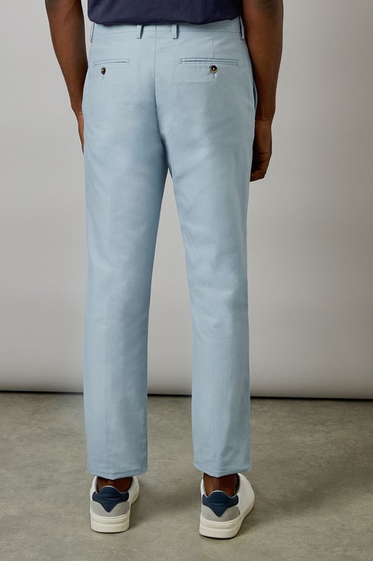 Crafted from a cotton-linen blend fabric for breathable comfort and a natural texture
        Slim fit design offers a modern, tailored silhouette that flatters the leg
        Clean front with side pockets and button-through back pockets for practicality
        Versatile light hue perfect for seasonal dressing throughout spring and summer
        Crisp centre crease adds structure and a refined finishing touch
    
    These Burton slim fit suit trousers combine classic tailoring with contemporary style. The cotton-linen blend fabric delivers a lightweight feel that's ideal for warmer weather whilst maintaining a smart appearance. Style with the matching jacket for formal occasions, or dress down with a navy crew neck and white trainers as shown for smart-casual events. The clean lines and refined cut make these trousers particularly suitable for summer weddings, garden parties, or race days. For the office, pair with a crisp shirt and loafers for a sophisticated look that transitions seamlessly from day to evening. The natural fabric blend allows for comfort during extended wear, making these trousers a practical yet stylish addition to any gentleman's wardrobe - perfect for the man who appreciates timeless style with modern sensibility.
