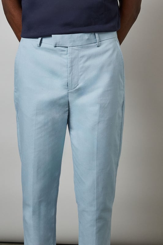 Crafted from a cotton-linen blend fabric for breathable comfort and a natural texture
        Slim fit design offers a modern, tailored silhouette that flatters the leg
        Clean front with side pockets and button-through back pockets for practicality
        Versatile light hue perfect for seasonal dressing throughout spring and summer
        Crisp centre crease adds structure and a refined finishing touch
    
    These Burton slim fit suit trousers combine classic tailoring with contemporary style. The cotton-linen blend fabric delivers a lightweight feel that's ideal for warmer weather whilst maintaining a smart appearance. Style with the matching jacket for formal occasions, or dress down with a navy crew neck and white trainers as shown for smart-casual events. The clean lines and refined cut make these trousers particularly suitable for summer weddings, garden parties, or race days. For the office, pair with a crisp shirt and loafers for a sophisticated look that transitions seamlessly from day to evening. The natural fabric blend allows for comfort during extended wear, making these trousers a practical yet stylish addition to any gentleman's wardrobe - perfect for the man who appreciates timeless style with modern sensibility.