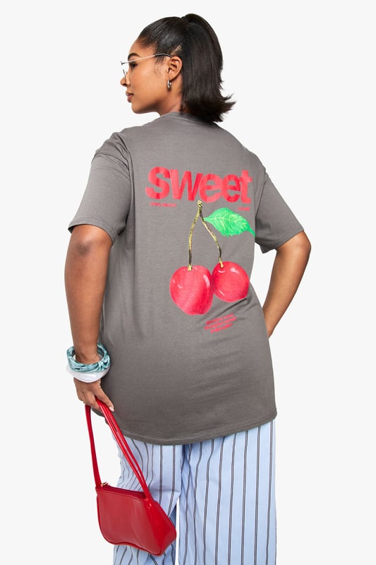 Oversized cotton t-shirt featuring a vibrant cherry graphic with 'Sweet' text print
        Relaxed crew neckline for everyday comfort
        Dropped shoulders and roomy sleeves for the perfect slouchy silhouette
        Generous length providing extra coverage and styling versatility
        Soft cotton fabric offering breathable comfort for all-day wear
    
    Make a statement with this eye-catching oversized t-shirt from boohoo's latest collection. The playful cherry graphic adds a fun, youthful touch to this casual essential. Style it as seen with striped trousers for a contemporary clash of patterns that works brilliantly for daytime outings. For a more relaxed approach, pair with denim shorts and trainers during warmer months, or layer under a denim jacket when the temperature drops. This versatile piece transitions effortlessly from casual coffee dates to weekend shopping trips. The generous fit makes it perfect for tucking into high-waisted bottoms or wearing loose for a more laid-back feel. Accessorise with chunky jewellery and a crossbody bag, as shown, to complete your look with personality and flair.