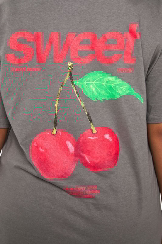 Oversized cotton t-shirt featuring a vibrant cherry graphic with 'Sweet' text print
        Relaxed crew neckline for everyday comfort
        Dropped shoulders and roomy sleeves for the perfect slouchy silhouette
        Generous length providing extra coverage and styling versatility
        Soft cotton fabric offering breathable comfort for all-day wear
    
    Make a statement with this eye-catching oversized t-shirt from boohoo's latest collection. The playful cherry graphic adds a fun, youthful touch to this casual essential. Style it as seen with striped trousers for a contemporary clash of patterns that works brilliantly for daytime outings. For a more relaxed approach, pair with denim shorts and trainers during warmer months, or layer under a denim jacket when the temperature drops. This versatile piece transitions effortlessly from casual coffee dates to weekend shopping trips. The generous fit makes it perfect for tucking into high-waisted bottoms or wearing loose for a more laid-back feel. Accessorise with chunky jewellery and a crossbody bag, as shown, to complete your look with personality and flair.