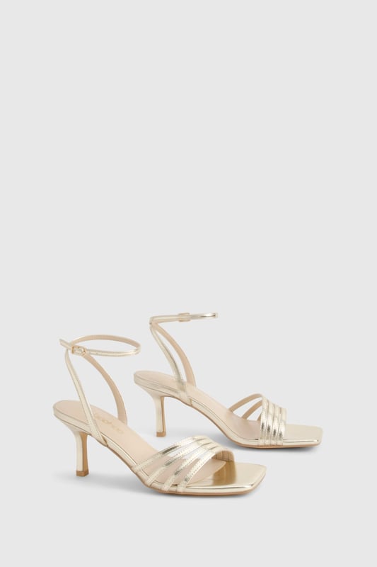 Elegant strappy design with multiple delicate bands across the front
        Sleek mid-height stiletto heel measuring between 5-6.5cm for comfortable elevation
        Secure ankle strap with adjustable buckle fastening
        Square-toe silhouette for contemporary appeal
        Versatile styling potential for both casual and formal occasions
    
    These sophisticated strappy heels strike the perfect balance between style and wearability. The mid-height stiletto offers just enough lift without compromising on comfort, making them ideal for dancing the night away. The delicate strappy design adds a touch of refinement to any ensemble, whilst the ankle strap ensures a secure fit throughout your evening. Style with a little black dress and statement clutch for cocktails with the girls, or pair with tailored trousers and a silky camisole for dinner dates. The square-toe silhouette brings a modern twist to this classic style, ensuring they remain on-trend season after season. These versatile heels transition effortlessly from day to night, making them an essential addition to your footwear collection for any social occasion in the urban nightlife scene.