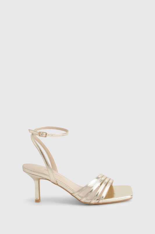 Elegant strappy design with multiple delicate bands across the front
        Sleek mid-height stiletto heel measuring between 5-6.5cm for comfortable elevation
        Secure ankle strap with adjustable buckle fastening
        Square-toe silhouette for contemporary appeal
        Versatile styling potential for both casual and formal occasions
    
    These sophisticated strappy heels strike the perfect balance between style and wearability. The mid-height stiletto offers just enough lift without compromising on comfort, making them ideal for dancing the night away. The delicate strappy design adds a touch of refinement to any ensemble, whilst the ankle strap ensures a secure fit throughout your evening. Style with a little black dress and statement clutch for cocktails with the girls, or pair with tailored trousers and a silky camisole for dinner dates. The square-toe silhouette brings a modern twist to this classic style, ensuring they remain on-trend season after season. These versatile heels transition effortlessly from day to night, making them an essential addition to your footwear collection for any social occasion in the urban nightlife scene.