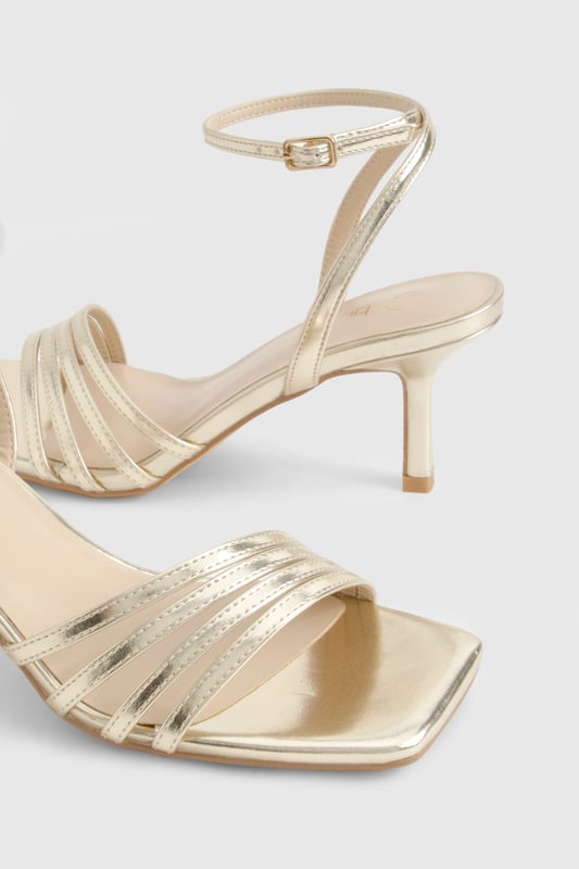 Elegant strappy design with multiple delicate bands across the front
        Sleek mid-height stiletto heel measuring between 5-6.5cm for comfortable elevation
        Secure ankle strap with adjustable buckle fastening
        Square-toe silhouette for contemporary appeal
        Versatile styling potential for both casual and formal occasions
    
    These sophisticated strappy heels strike the perfect balance between style and wearability. The mid-height stiletto offers just enough lift without compromising on comfort, making them ideal for dancing the night away. The delicate strappy design adds a touch of refinement to any ensemble, whilst the ankle strap ensures a secure fit throughout your evening. Style with a little black dress and statement clutch for cocktails with the girls, or pair with tailored trousers and a silky camisole for dinner dates. The square-toe silhouette brings a modern twist to this classic style, ensuring they remain on-trend season after season. These versatile heels transition effortlessly from day to night, making them an essential addition to your footwear collection for any social occasion in the urban nightlife scene.