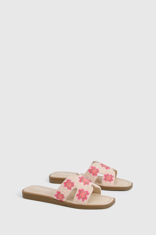 Charming crochet slide sandals featuring a delicate floral pattern
        Comfortable flat design with a heel height between 0-2cm for all-day wear
        Wide single strap across the foot for easy slip-on styling
        Cushioned footbed providing essential comfort for summer adventures
        Durable wooden-effect sole with subtle stacked appearance
    
    These crochet cut-out sandals bring a touch of artisanal charm to your summer wardrobe. The intricate floral crochet detailing adds texture and visual interest to an otherwise simple silhouette, making these slides perfect for the fashion-forward woman who appreciates handcrafted details. Pair with frayed denim shorts and an oversized linen shirt for casual beach days, or style with a flowing maxi dress for garden parties and family gatherings. The flat design ensures comfort whilst strolling through farmers' markets or enjoying afternoon tea with friends. These versatile sandals transition effortlessly from daytime casual to relaxed evening settings, making them an essential addition to your holiday packing list. Their slip-on design offers convenience without compromising on style, embodying the carefree spirit of summer dressing that Boohoo customers adore.
