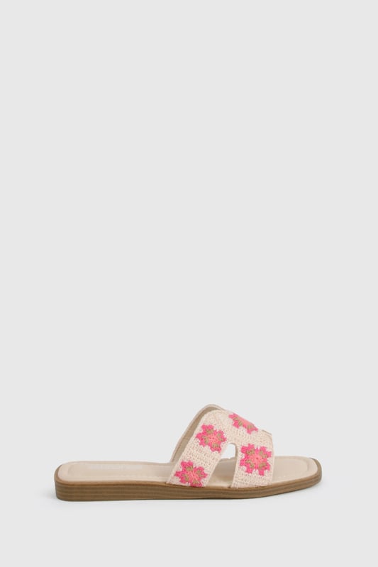 Charming crochet slide sandals featuring a delicate floral pattern
        Comfortable flat design with a heel height between 0-2cm for all-day wear
        Wide single strap across the foot for easy slip-on styling
        Cushioned footbed providing essential comfort for summer adventures
        Durable wooden-effect sole with subtle stacked appearance
    
    These crochet cut-out sandals bring a touch of artisanal charm to your summer wardrobe. The intricate floral crochet detailing adds texture and visual interest to an otherwise simple silhouette, making these slides perfect for the fashion-forward woman who appreciates handcrafted details. Pair with frayed denim shorts and an oversized linen shirt for casual beach days, or style with a flowing maxi dress for garden parties and family gatherings. The flat design ensures comfort whilst strolling through farmers' markets or enjoying afternoon tea with friends. These versatile sandals transition effortlessly from daytime casual to relaxed evening settings, making them an essential addition to your holiday packing list. Their slip-on design offers convenience without compromising on style, embodying the carefree spirit of summer dressing that Boohoo customers adore.